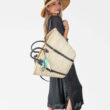 French Market Basket Backpack in Natural/Black with model standing wearing sun hat